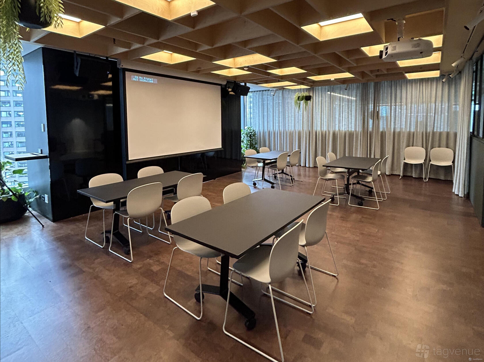 A meeting room with dark rectangular tables, white chairs, a ceiling projector, and floor-to-ceiling windows at Space&Co. 8 Exhibition Street, Melbourne.