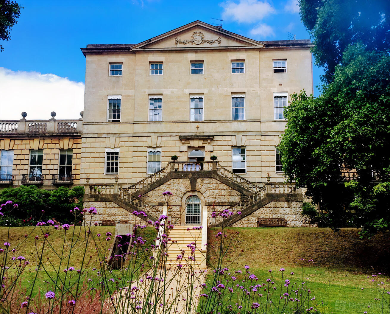 A historic building with grand stone steps, tall sash windows, and landscaped gardens at Clifton Hill House.