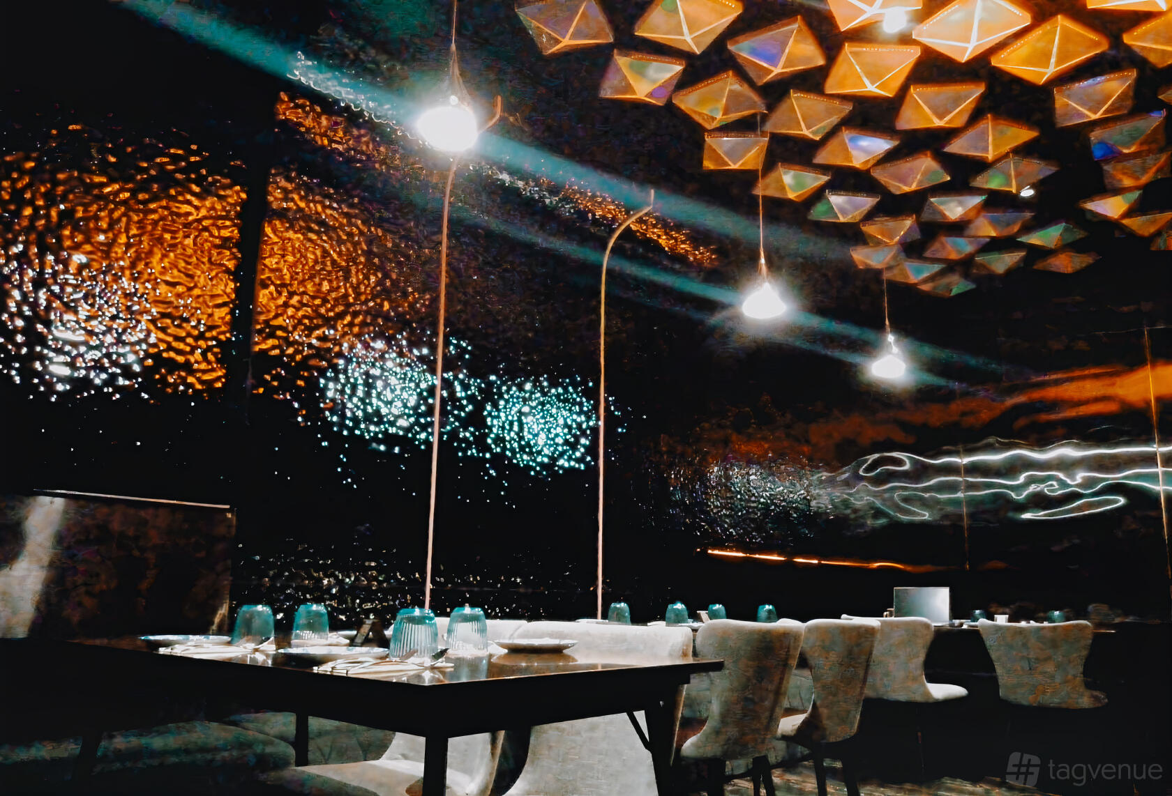 An event space in a restaurant with geometric ceiling panels, textured dark walls, and banquet tables at Synthesis 食拿酒稳.