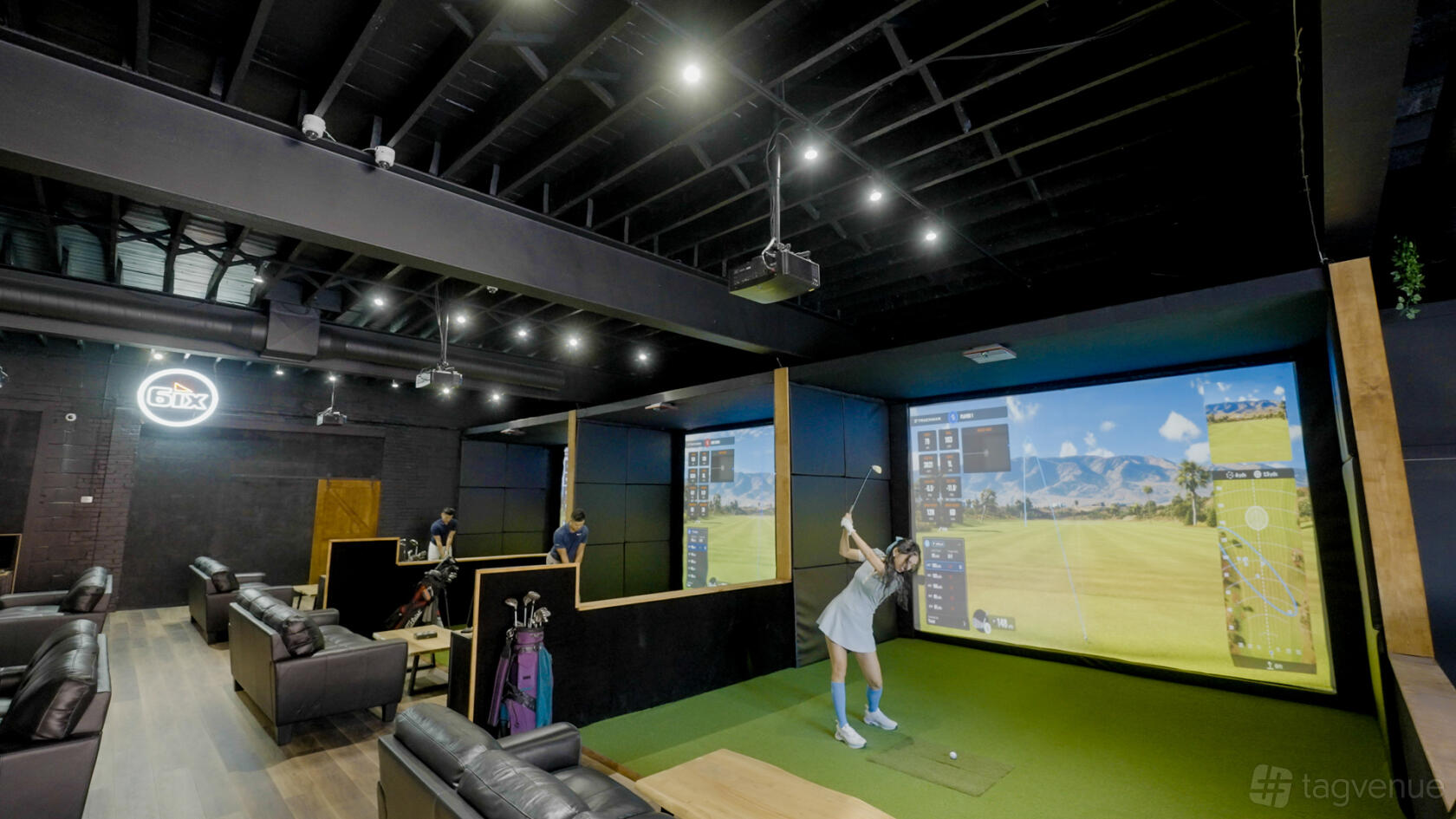 An event space with golf simulators, lounge seating, and large digital screens at 6IX Iron Golf Sim Event & Team Building Space.