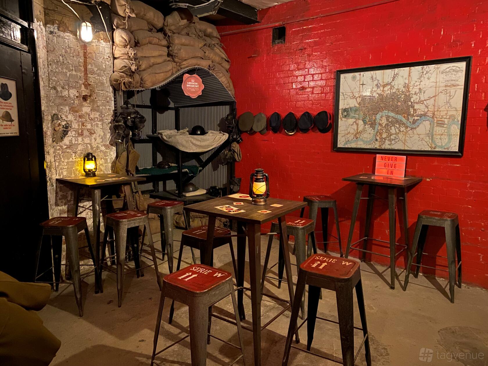 An event venue with high tables, stools, red brick walls, and vintage decor at Mission: Breakout.