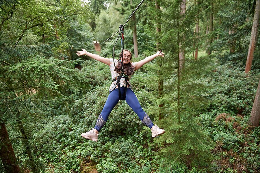 An outdoor adventure course with ziplining among tall pine trees at Go Ape Sherwood Pines.
