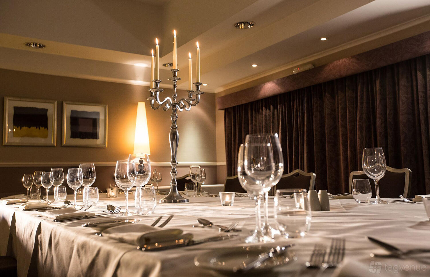 A banquet room with a long dining table, candelabra centerpiece, and place settings at The Priest House Hotel.