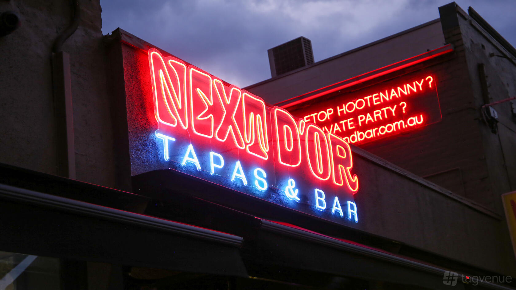 A bar with neon signage reading 'Next D'Or Tapas & Bar' on the exterior at Next D'Or Tapas Hawthorn.