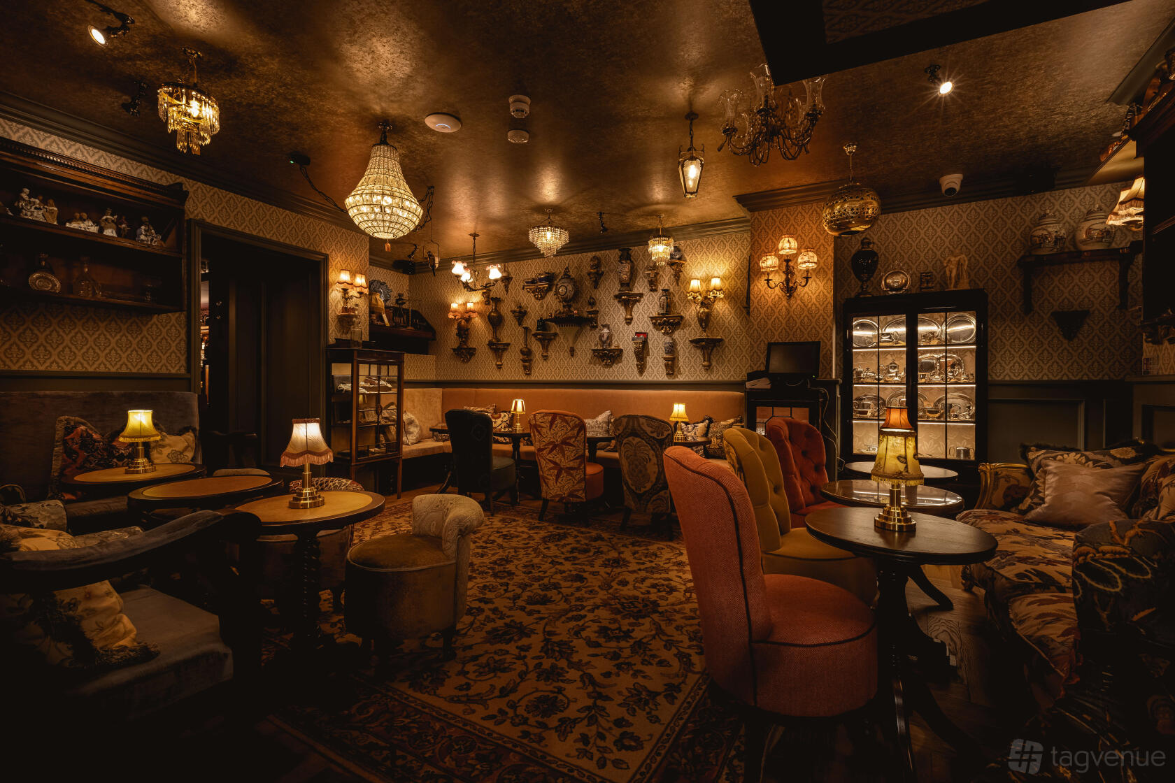 An intimate cocktail bar event space with patterned wallpaper, vintage armchairs, and warm ambient lighting at Mr Foggs Pawnbrokers.