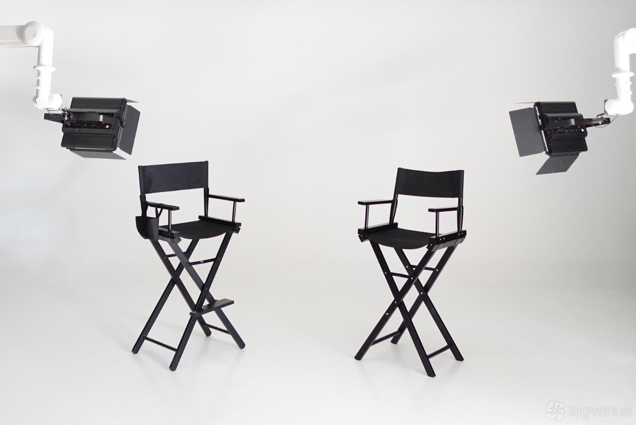 A photo studio with two director's chairs, white seamless backdrop, and professional lighting at Studio 882.