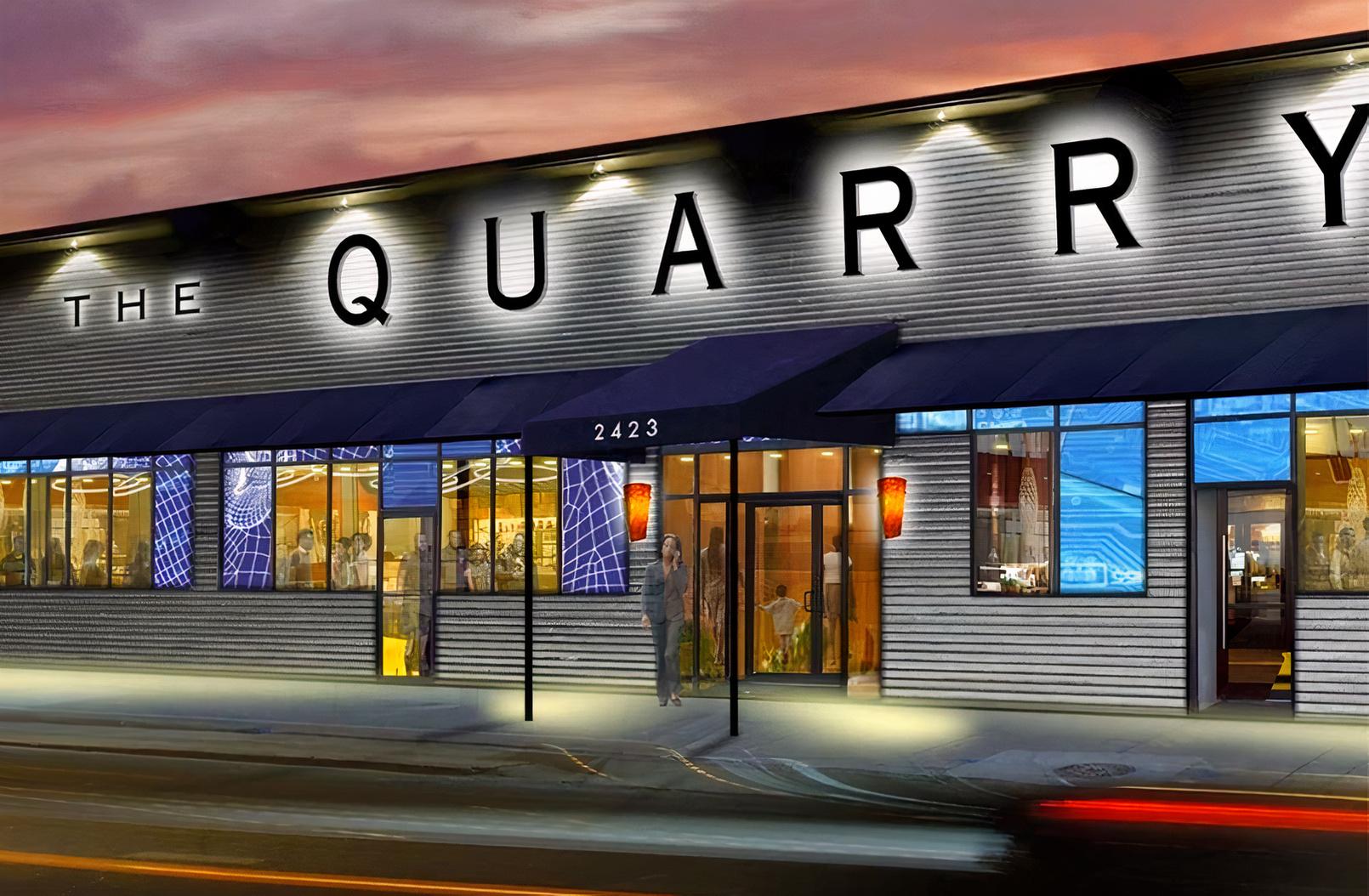 A versatile event space with a corrugated metal exterior, large windows, and a blue awning at The Quarry Event Center.