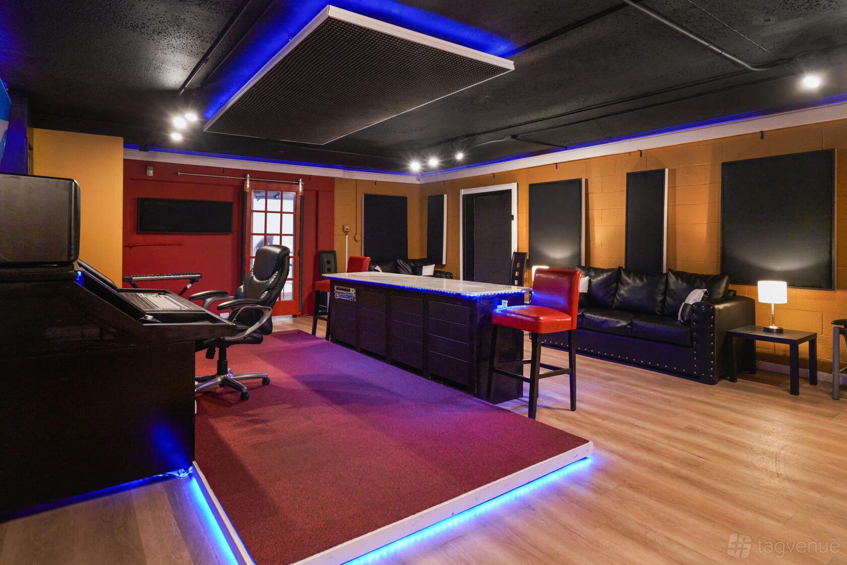 An event venue with a recording studio setup, LED accent lighting, and a seating area at BCE Studios.