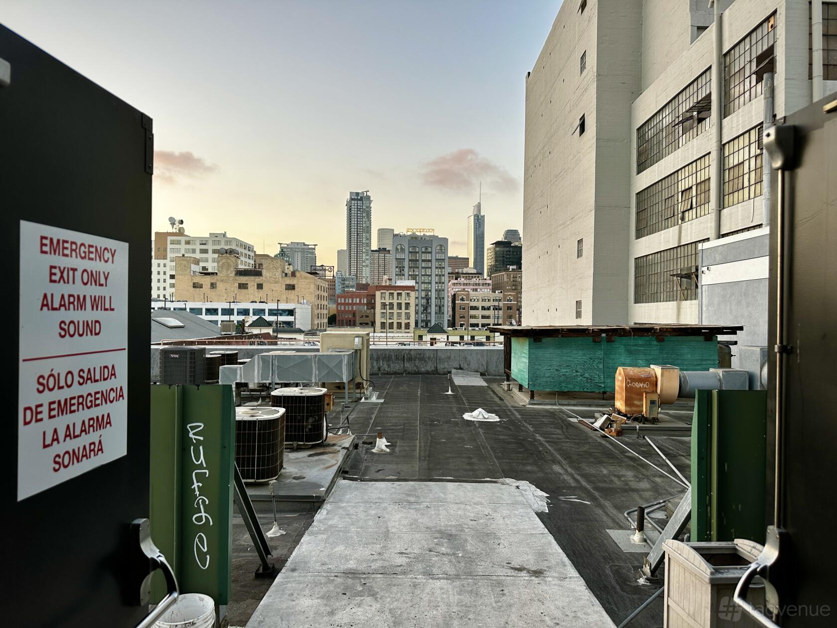 An open air rooftop with city skyline views and industrial equipment at San Julian Cityscape.