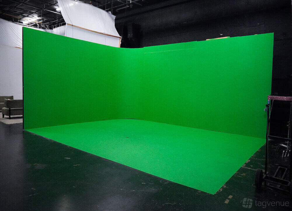 A photo studio with a large three-wall green screen cyclorama and dark painted floors at M3 Studios.