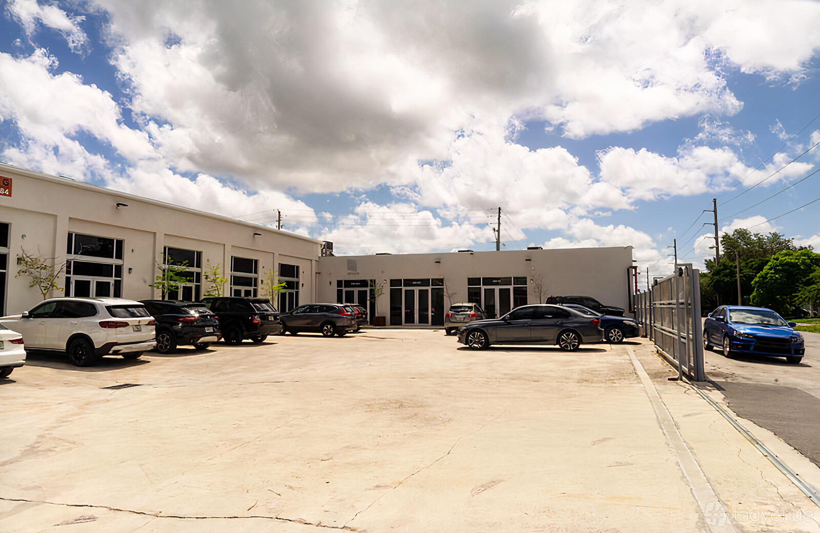 A film and photo studio with a large parking lot, multiple cars, and a white exterior at ALT Photo Studio LLC.