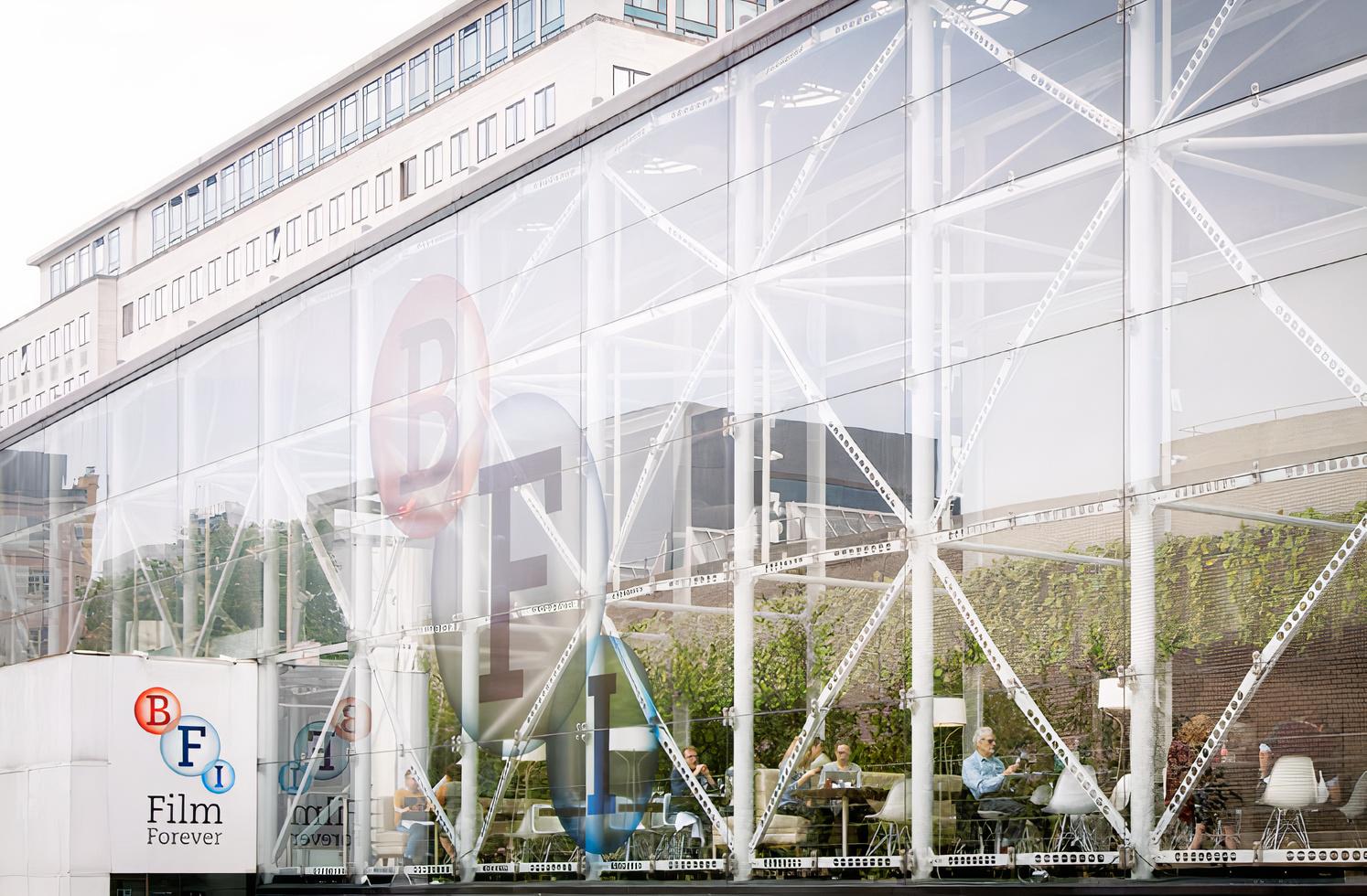 A restaurant with floor-to-ceiling glass walls and visible seating at Benugo @ The BFI Southbank.