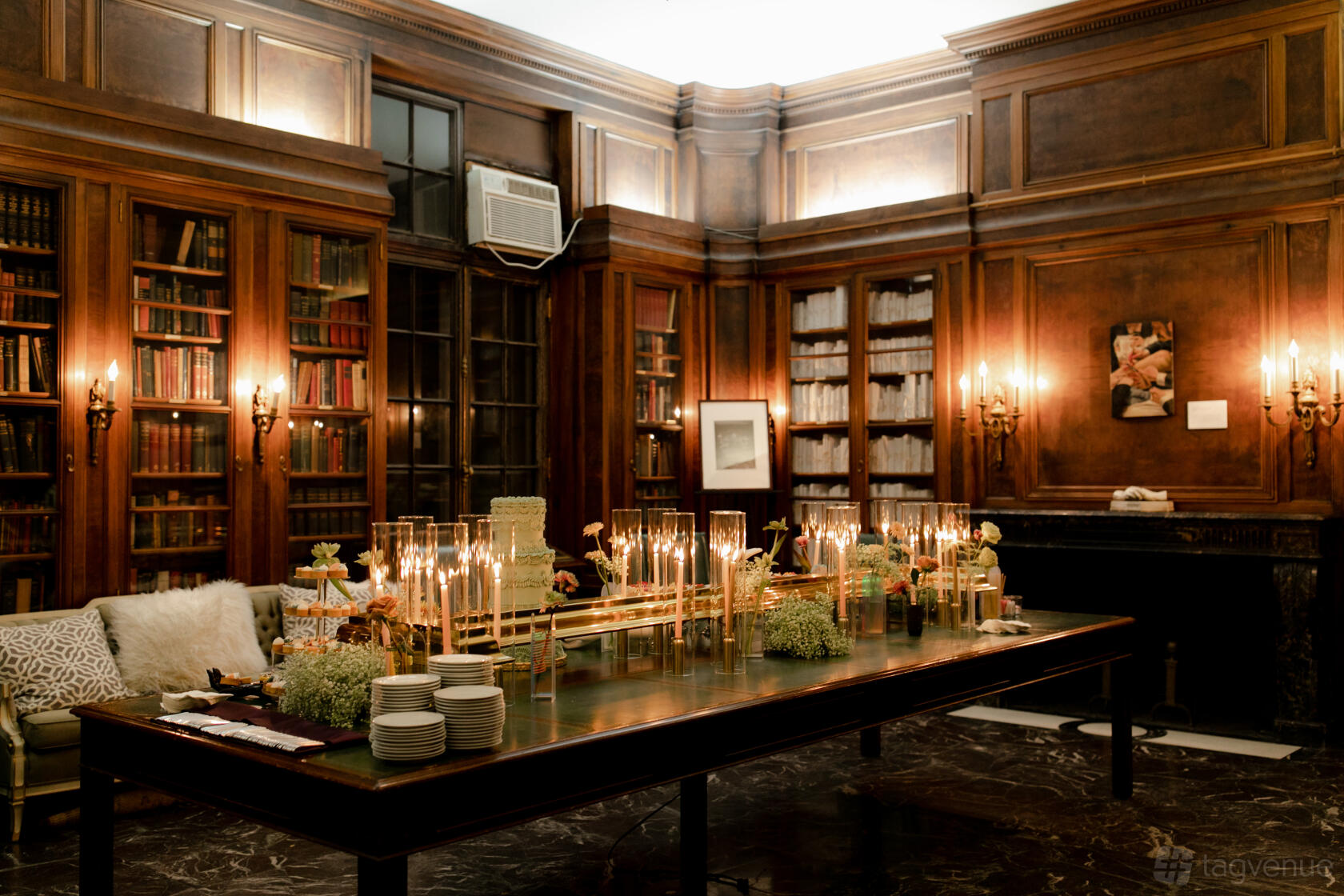 A museum room with wood-paneled walls, built-in bookshelves, marble fireplace, and a long dining table with candles at International Museum of Surgical Science.