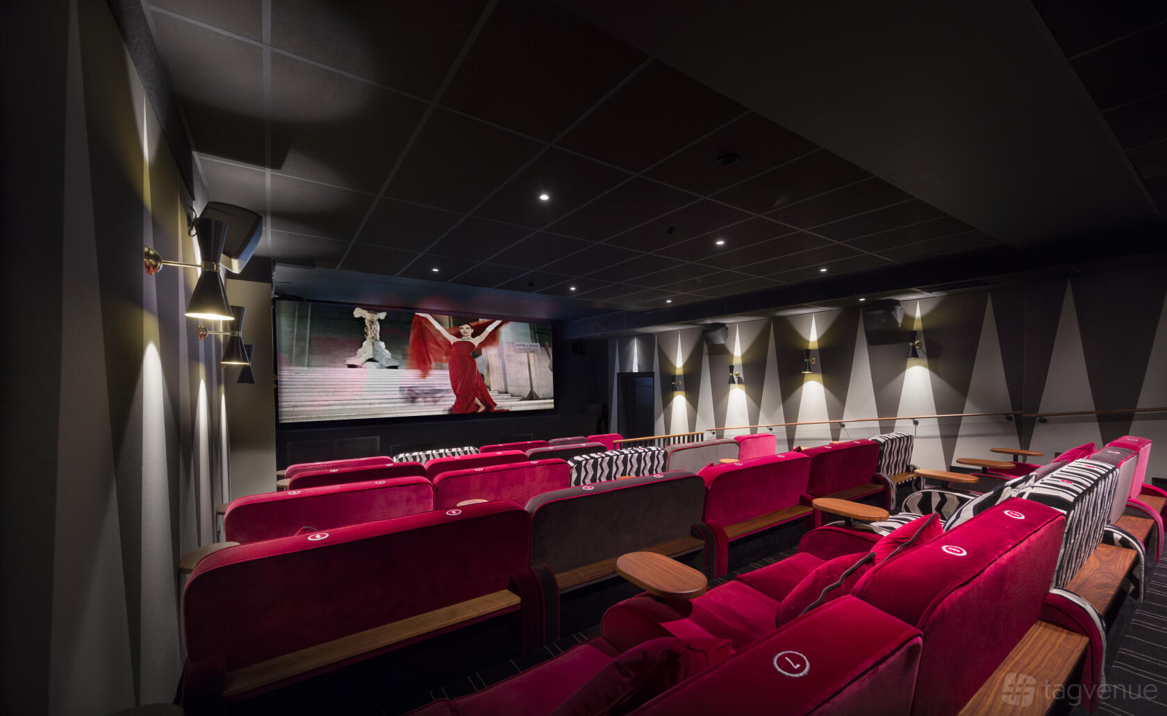An auditorium with red velvet seats, wall sconces, and a large screen at Everyman Newcastle.