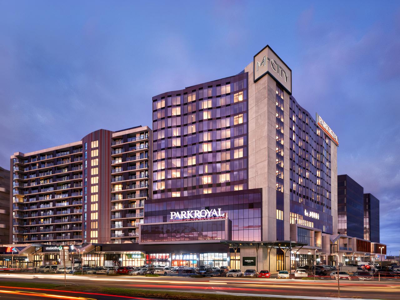 A hotel exterior with illuminated windows, modern facade, and PARKROYAL Monash Melbourne signage at PARKROYAL Monash Melbourne.
