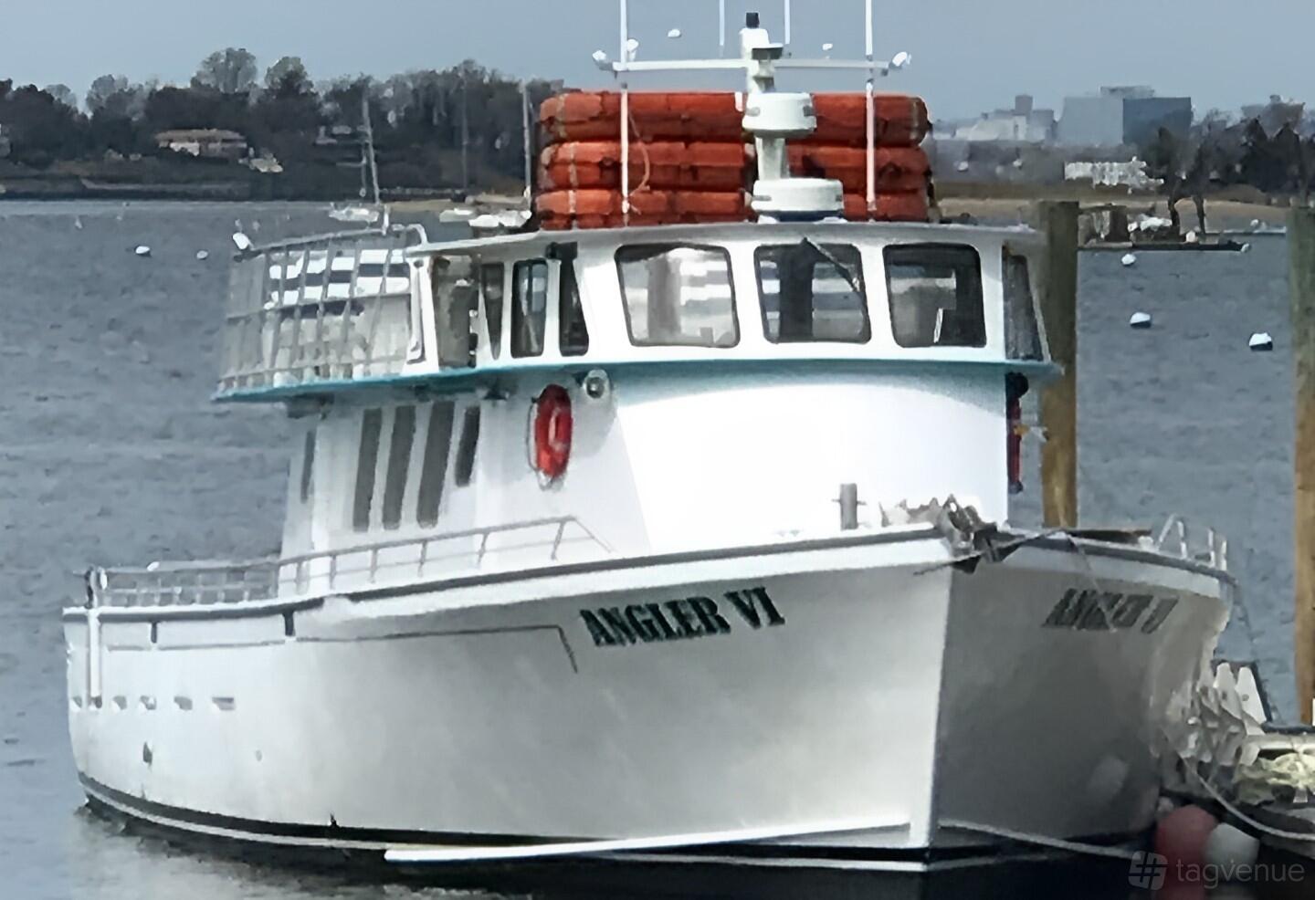 A charter boat with large cabin windows, outdoor seating, and stacked life vests on deck at The Angler Fleet