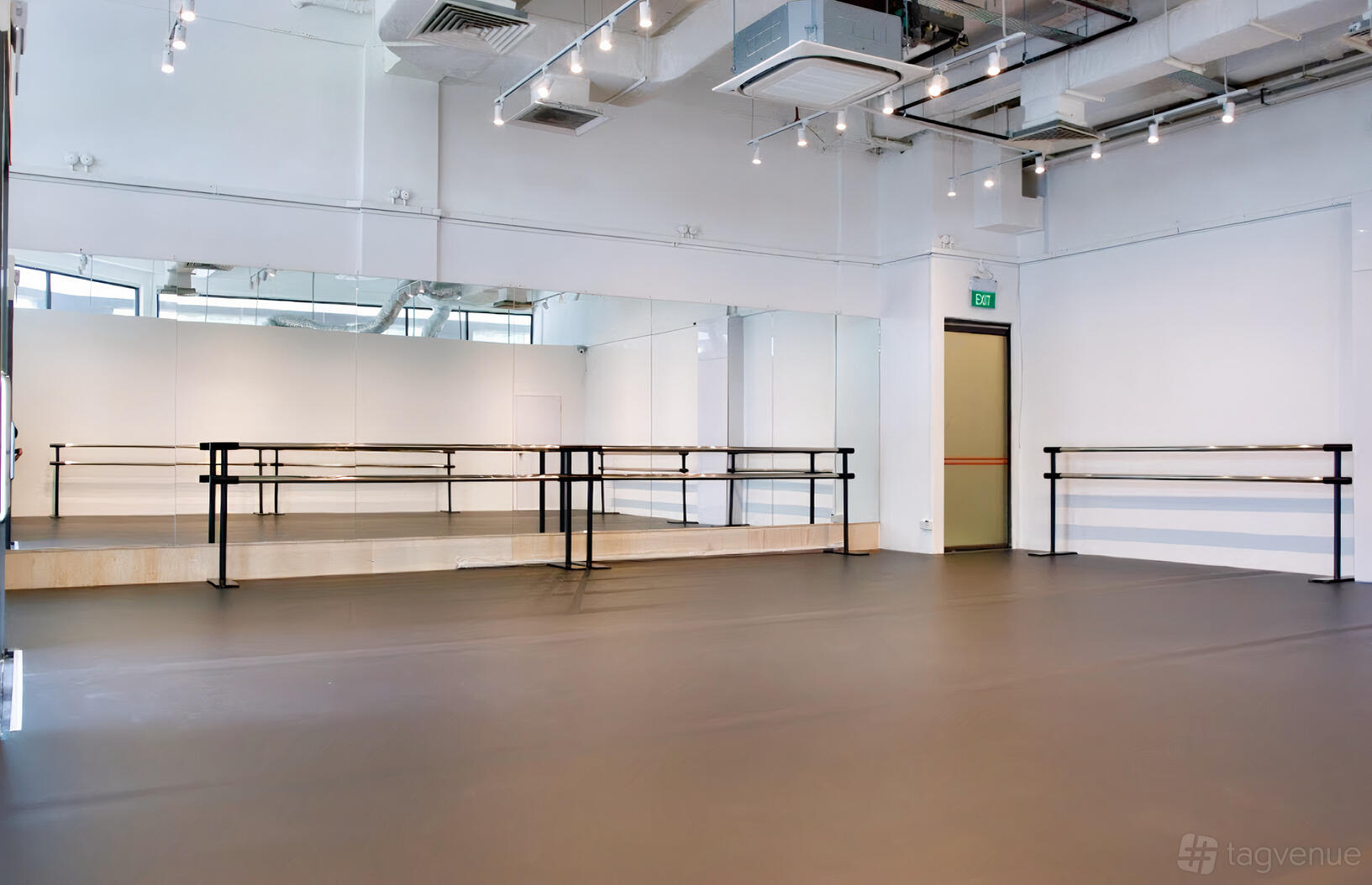 A dance studio with floor-to-ceiling mirrors, ballet barres, and track lighting at The Ballet Academy @ SIN MING BRANCH.