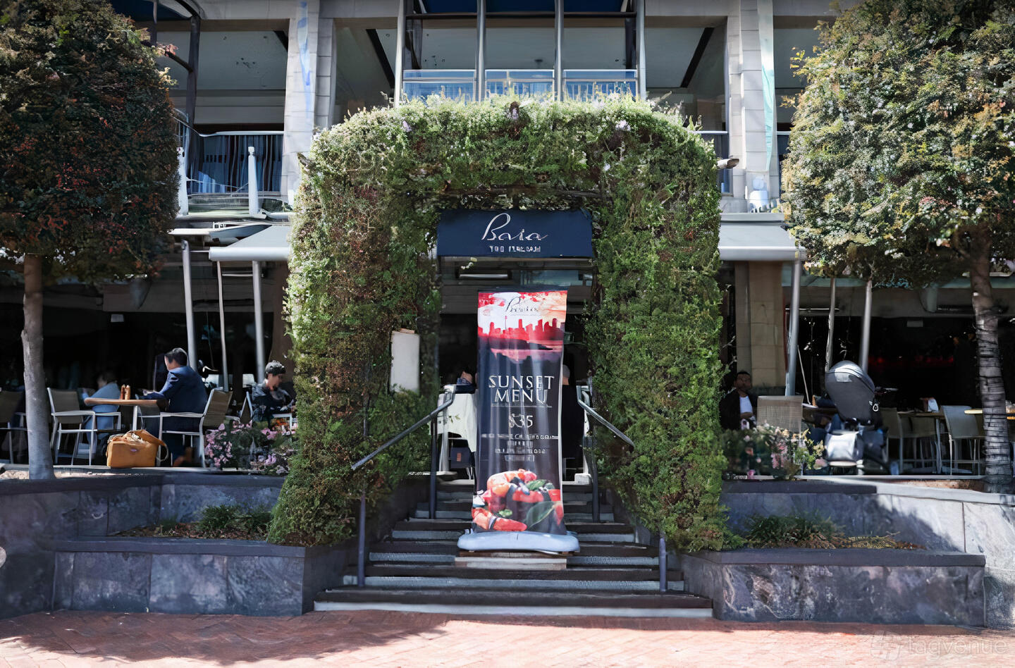 A restaurant entrance framed by a green ivy archway and outdoor seating at Baia The Italian.