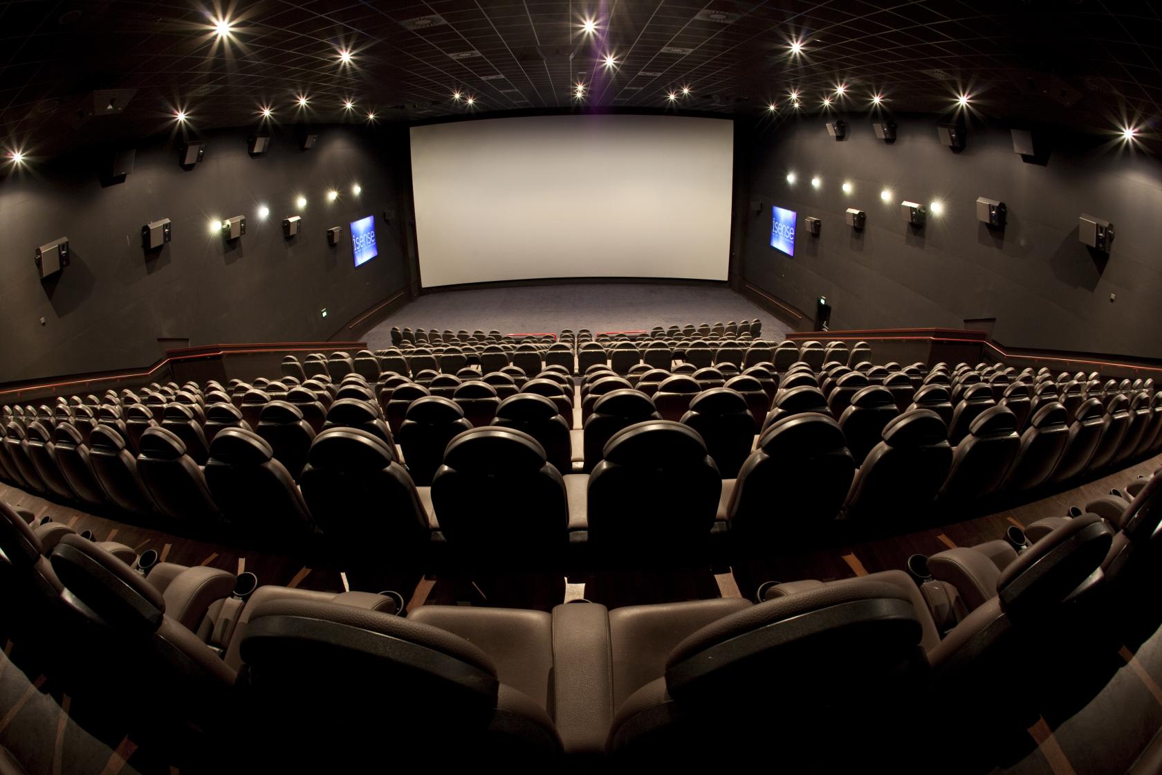A cinema auditorium with tiered leather recliner seating and a large widescreen at ODEON LUXE Birmingham Broadway Plaza.