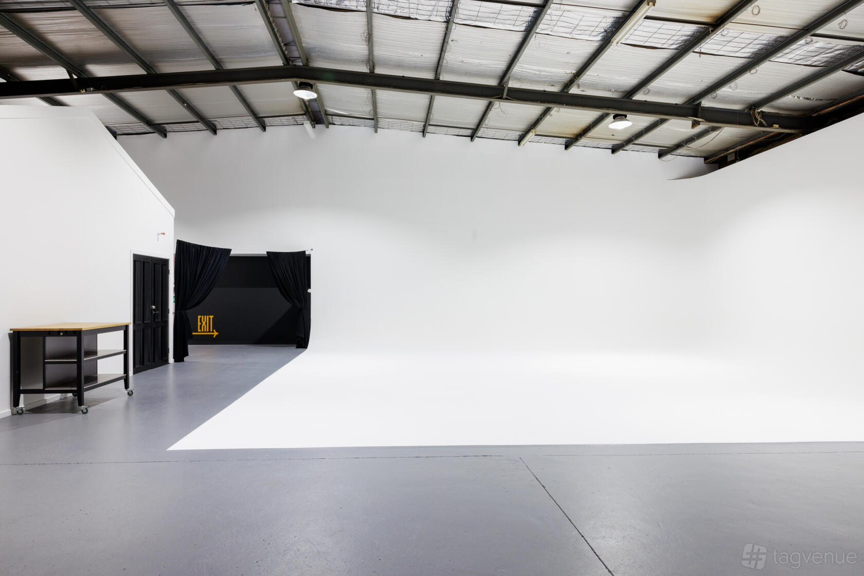A photo studio with a large white cyclorama wall, high ceilings, and concrete floors at Monster & Bear Studios.
