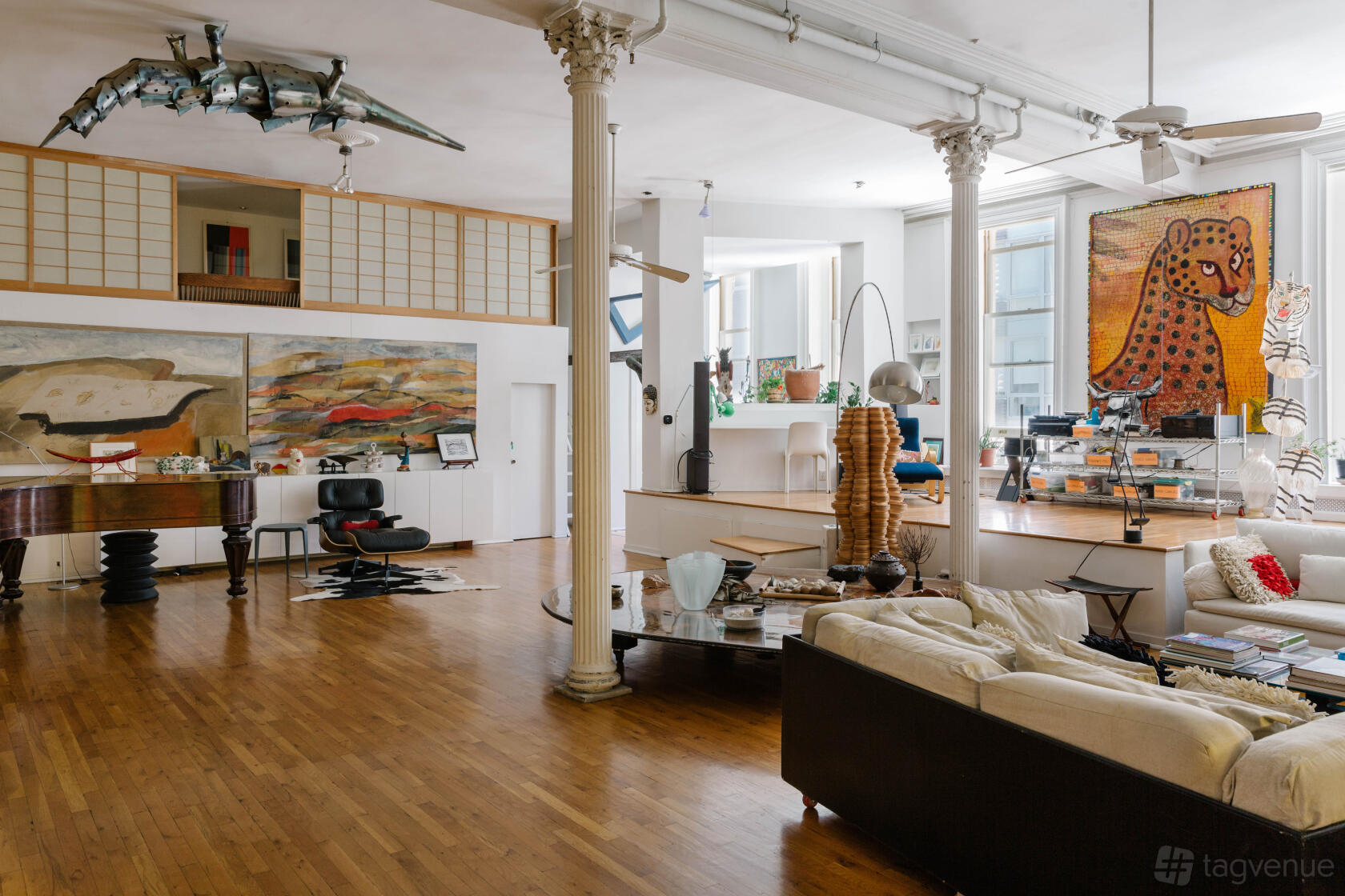 An apartment with hardwood floors, large windows, white columns, and eclectic artwork at Casa San Andres.
