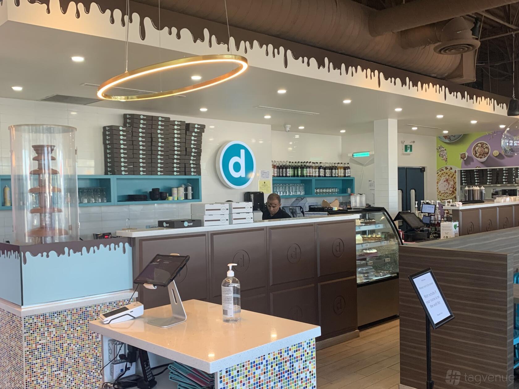A restaurant with a dessert counter, chocolate fountain, and open kitchen at D Spot Dessert Cafe - Hamilton.