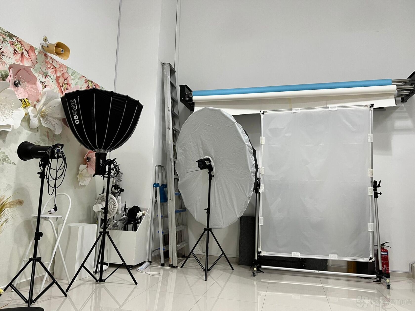 A photo studio with backdrop rolls, softbox lighting, and reflective umbrellas at Mama Miyo.