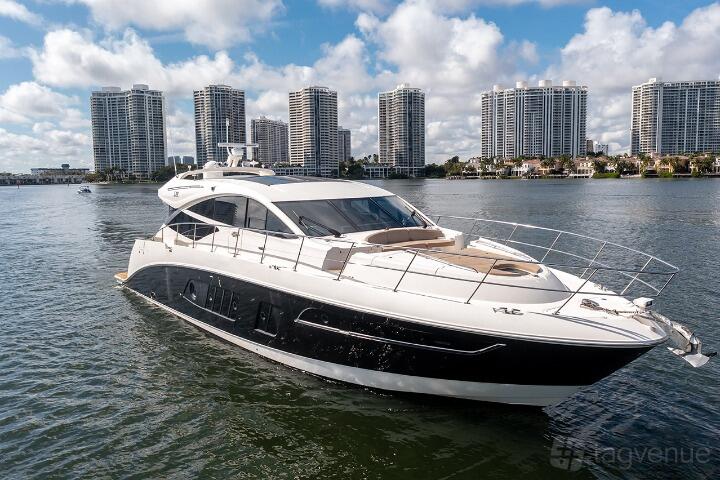 A sleek yacht with spacious deck seating and large windows on the water at UNIQ YACHT CHARTERS.