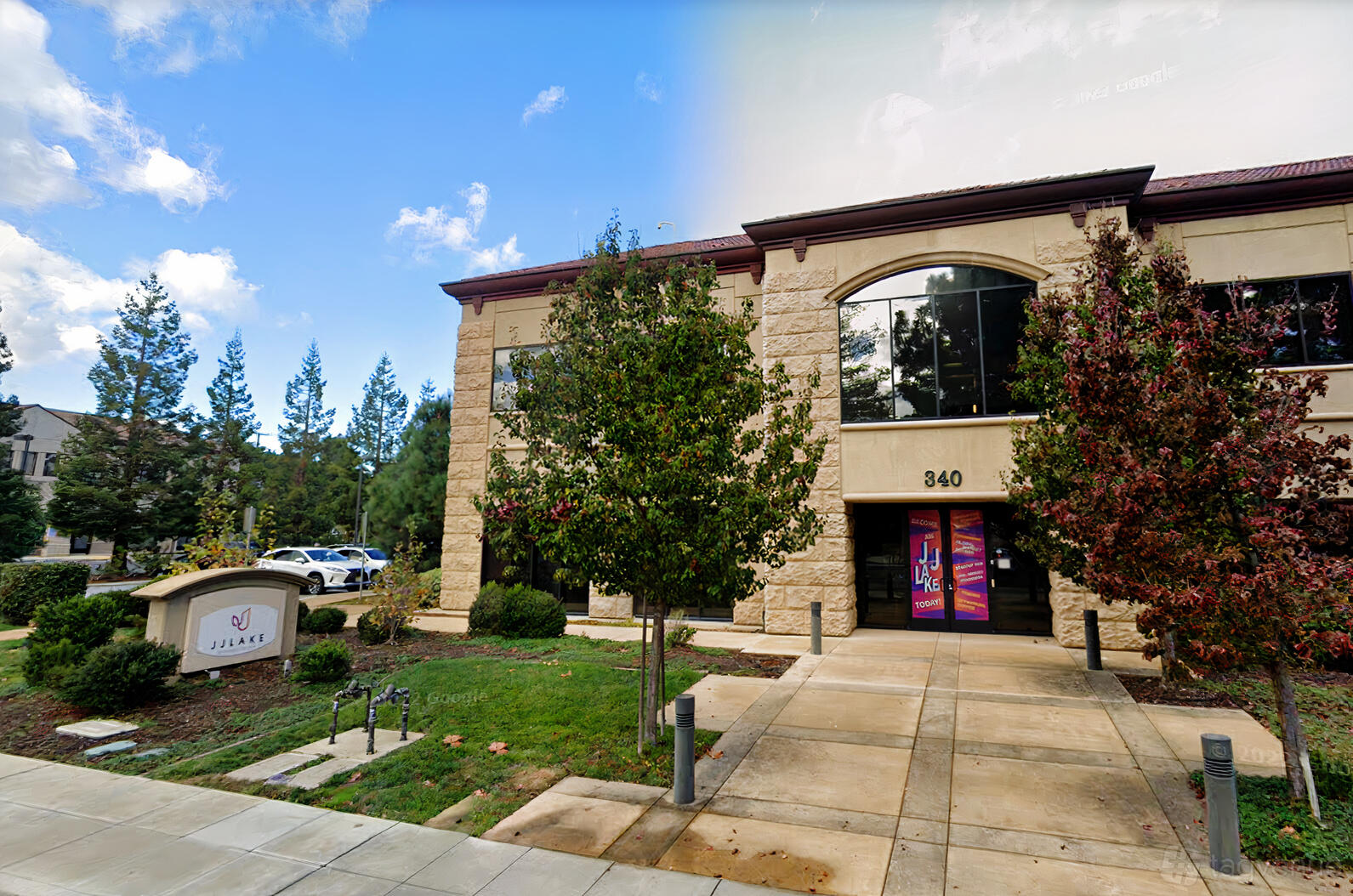 A meeting centre with a stone facade, large arched windows, and landscaped greenery at JJ Lake Business Center.