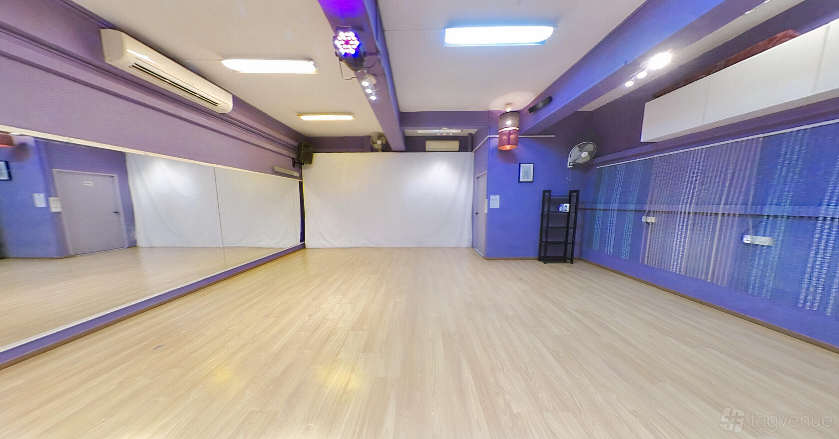 A dance studio with mirrored walls, light wood flooring, and purple accents at Bolly Dancing Studio.