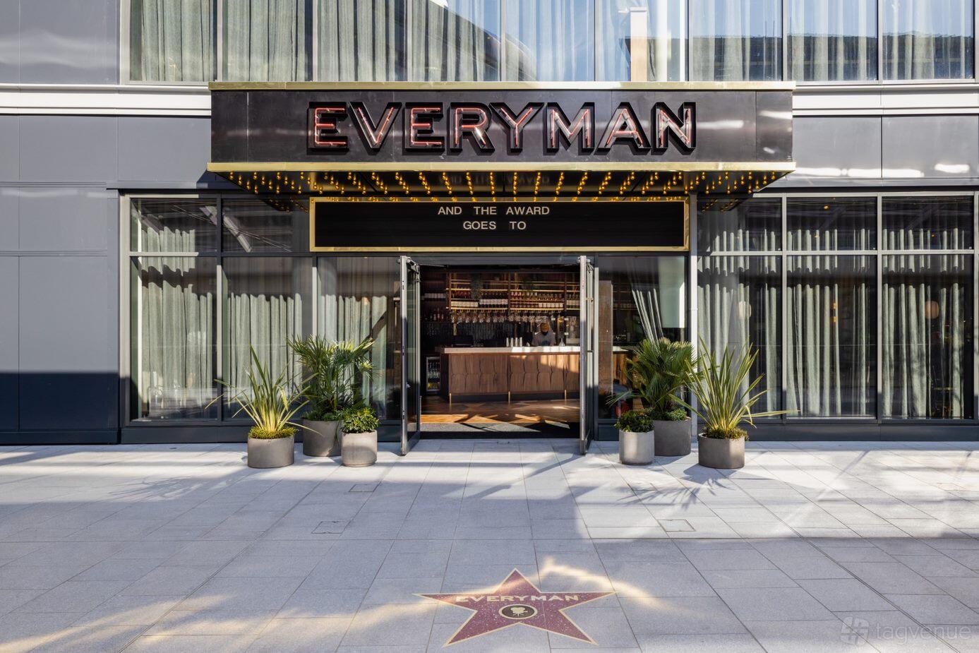 A cinema entrance with glass doors, marquee signage, and potted plants at Everyman Edinburgh.