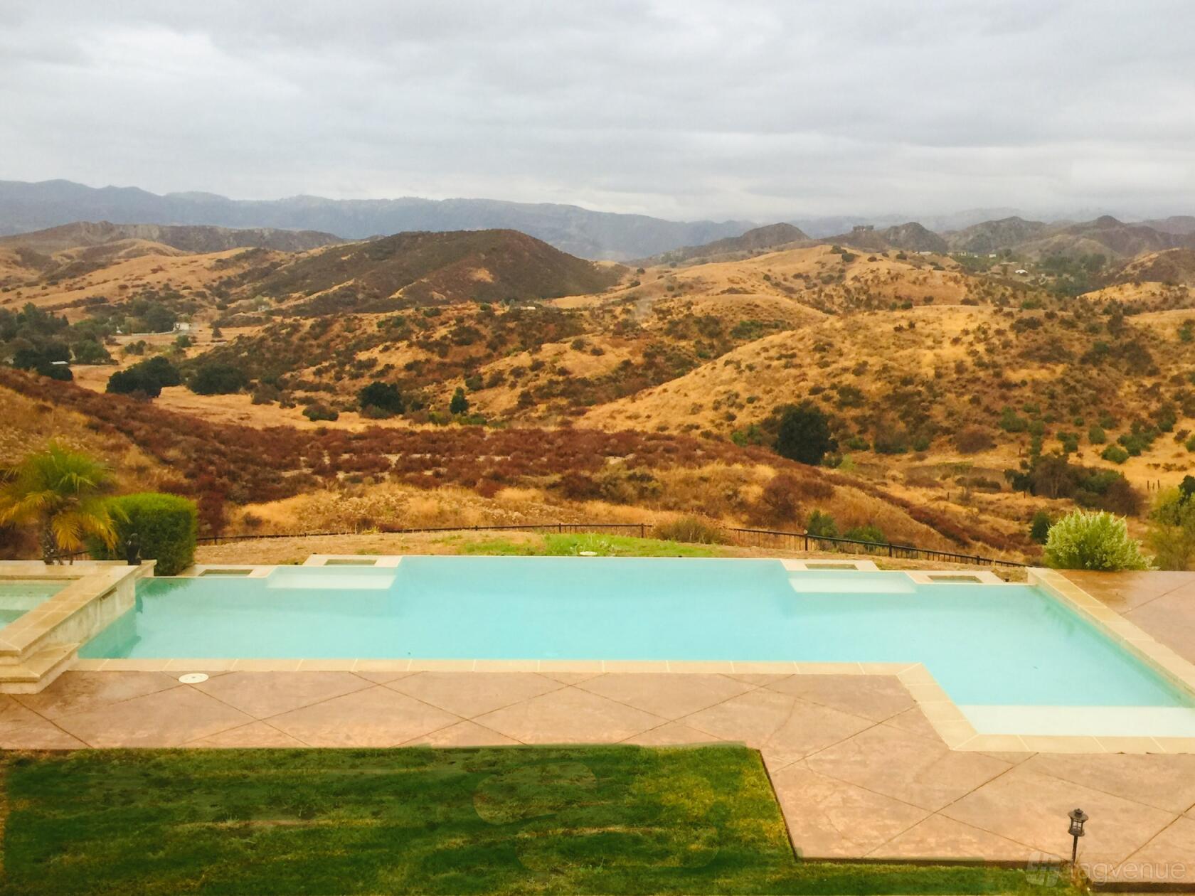An infinity pool overlooking rolling hills and open landscape at LA Infinity Hilltop Resort.