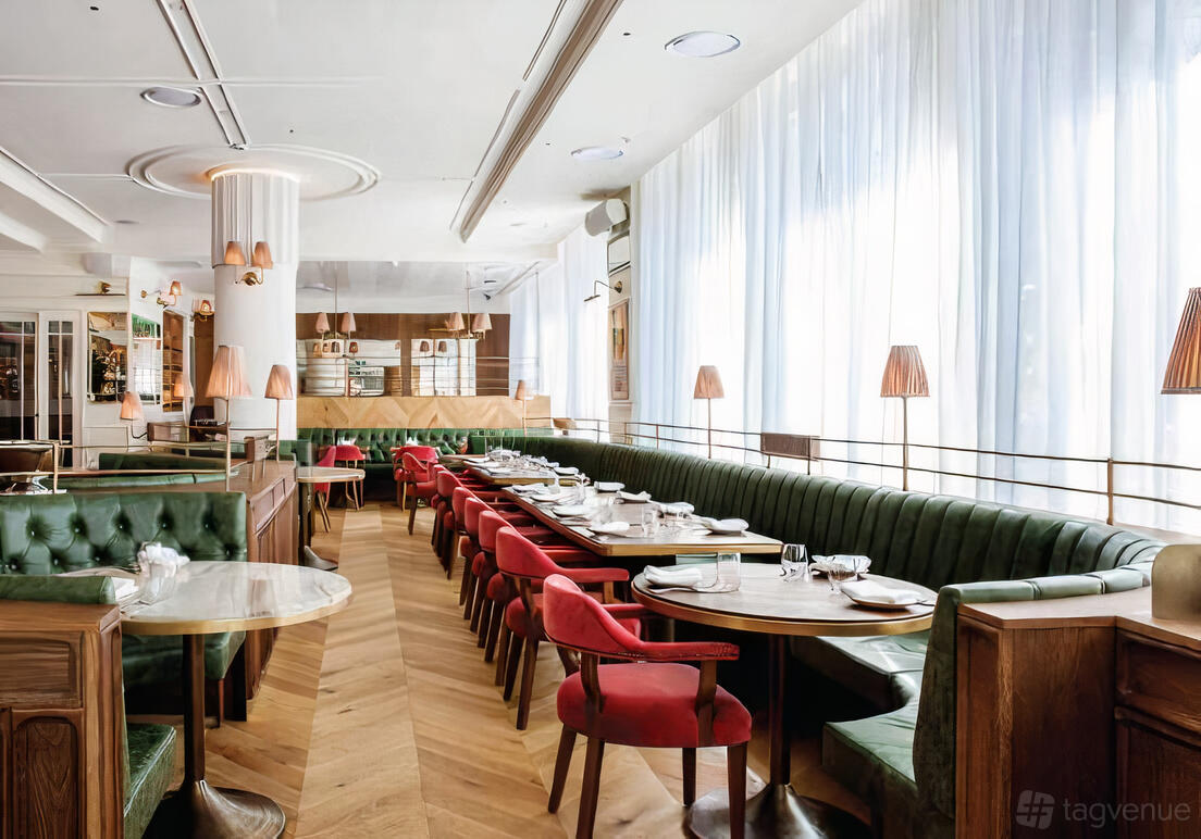 A hotel dining room with green tufted banquettes, red chairs, and floor-to-ceiling sheer curtains at Spicers Potts Point.
