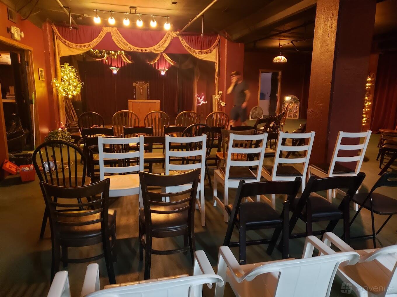 A church event space with mismatched chairs, decorative lighting, and a small stage at The Lost Church San Francisco.