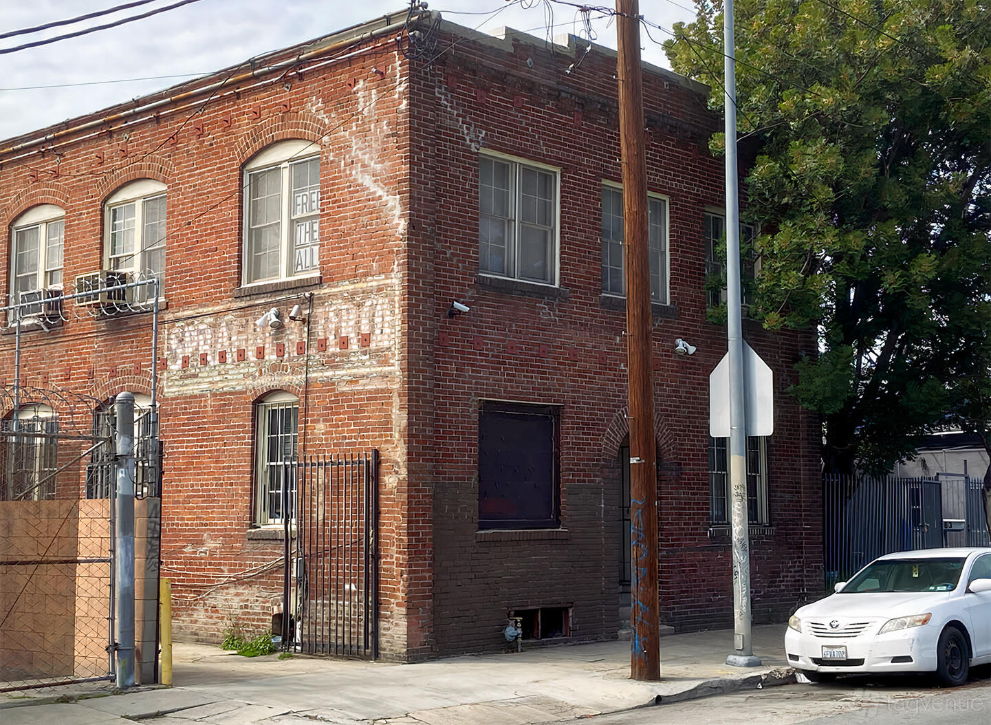 A film and photo studio with an industrial red brick exterior, barred windows, and metal gates at Modern Tintype.