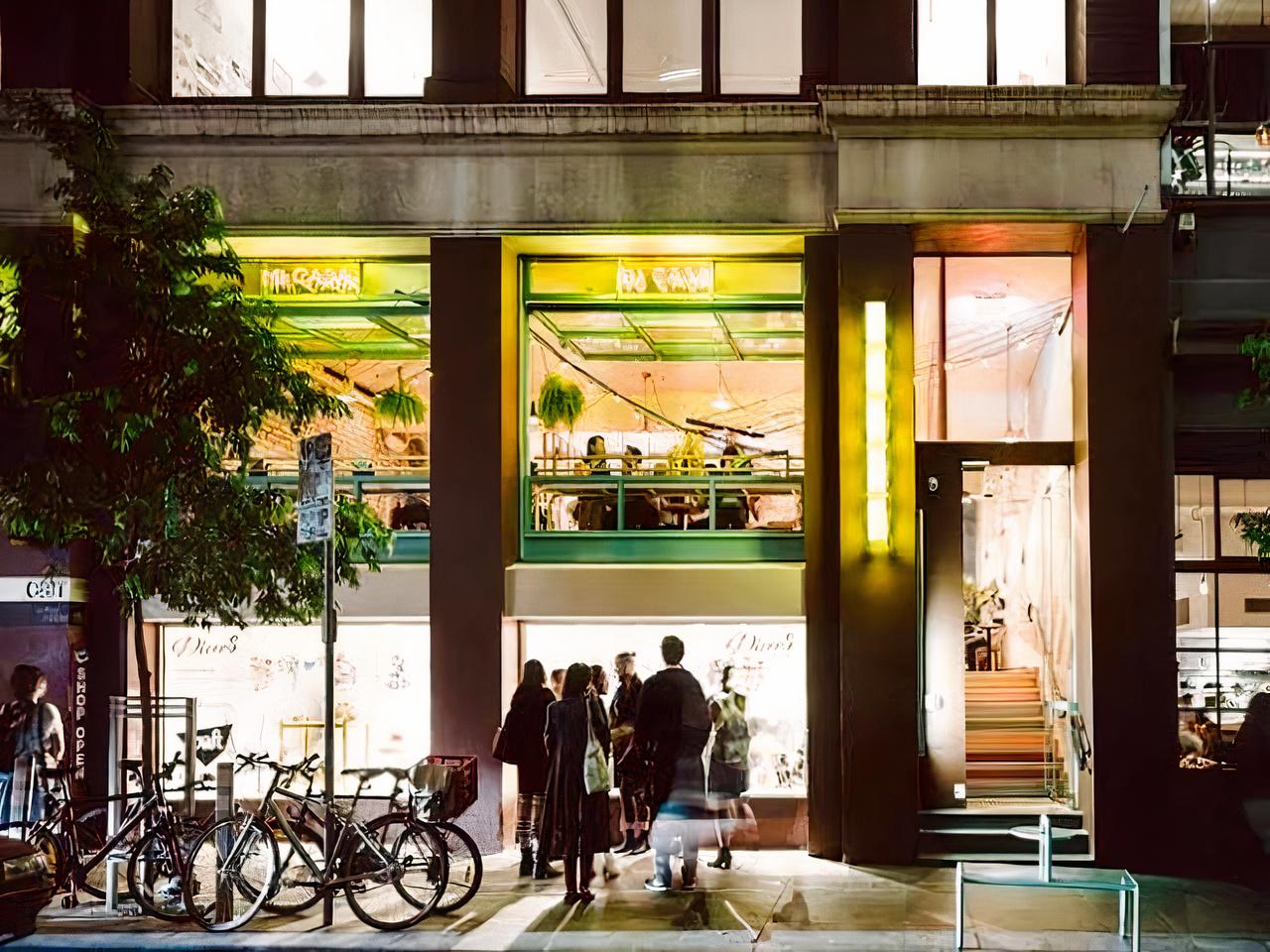 A restaurant with floor-to-ceiling windows, visible indoor seating, and neon signage at Fonda Mexican @ Flinders Lane.