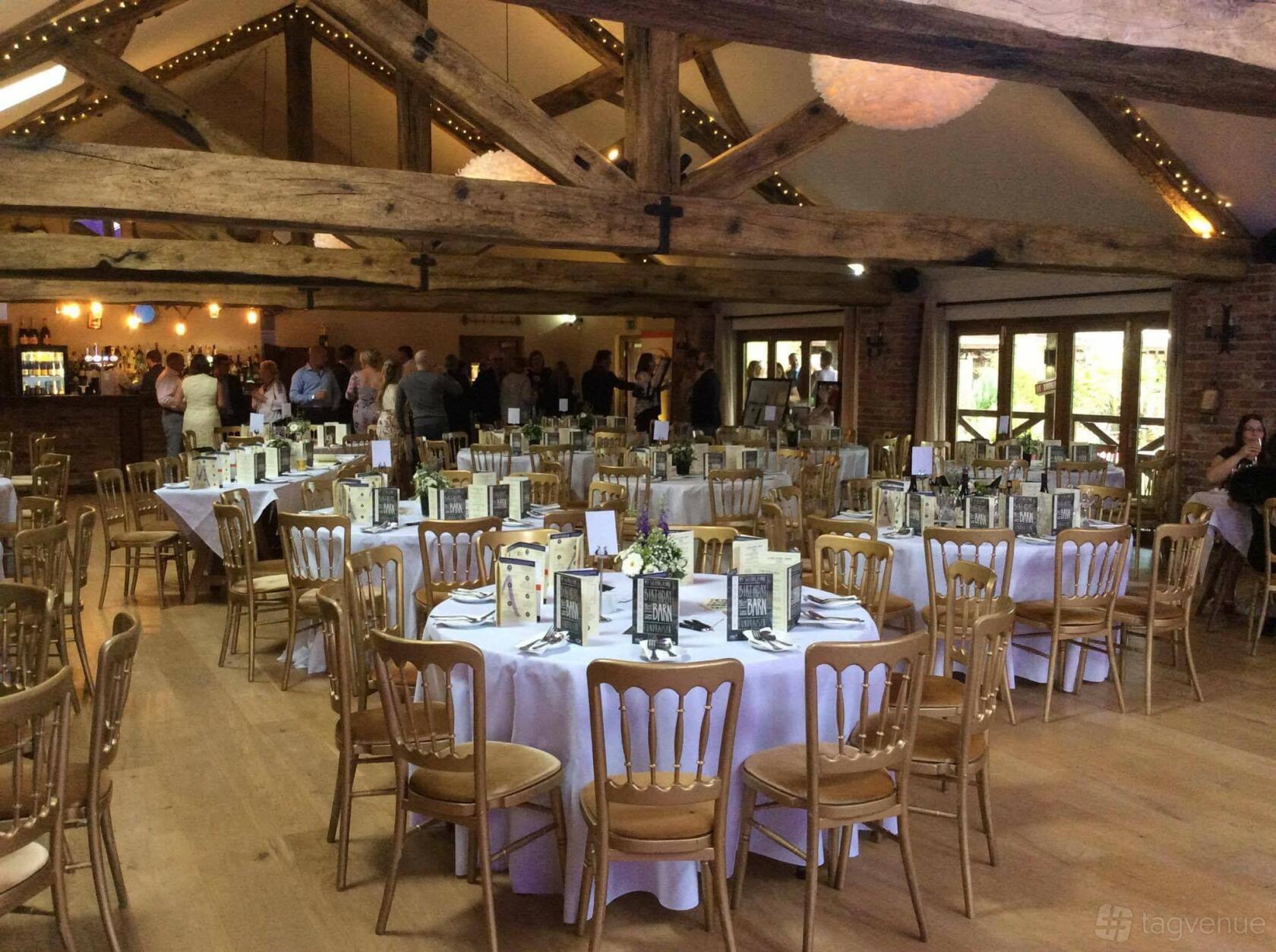 An event space in a restaurant with exposed wooden beams, round tables with menus, and wooden chairs at Whinstone View.