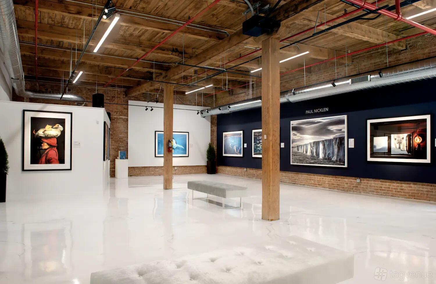 An event venue with exposed brick walls, wooden beams, and framed artwork displays at Morgan Arts Complex.