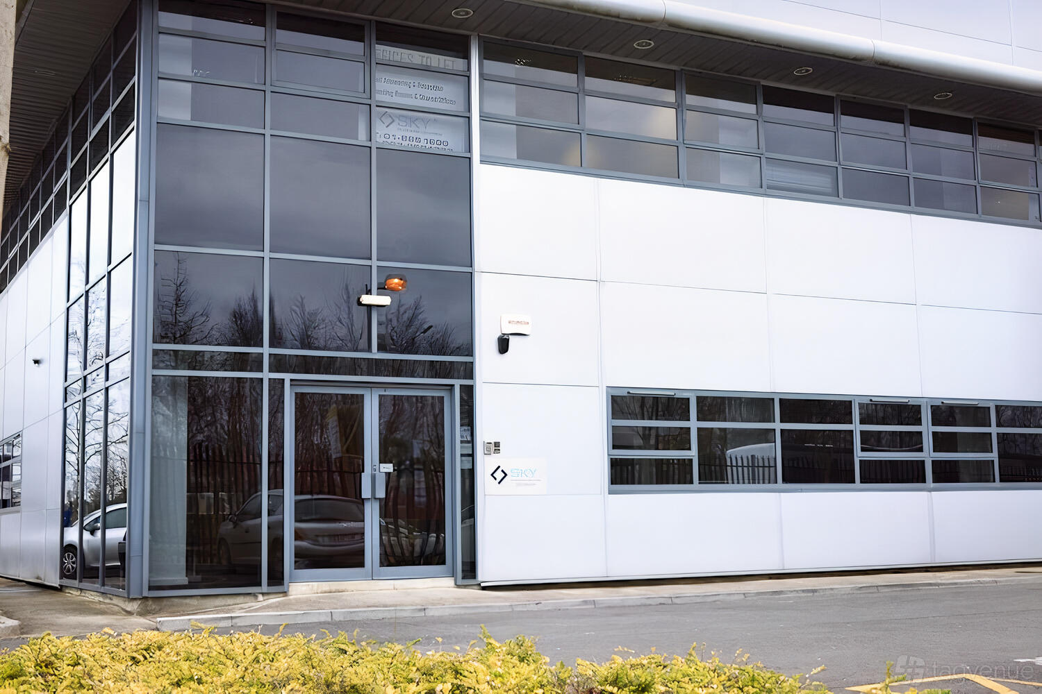 A meeting centre with large glass windows, silver cladding, and a glass entrance at Sky Business Centre Damastown.