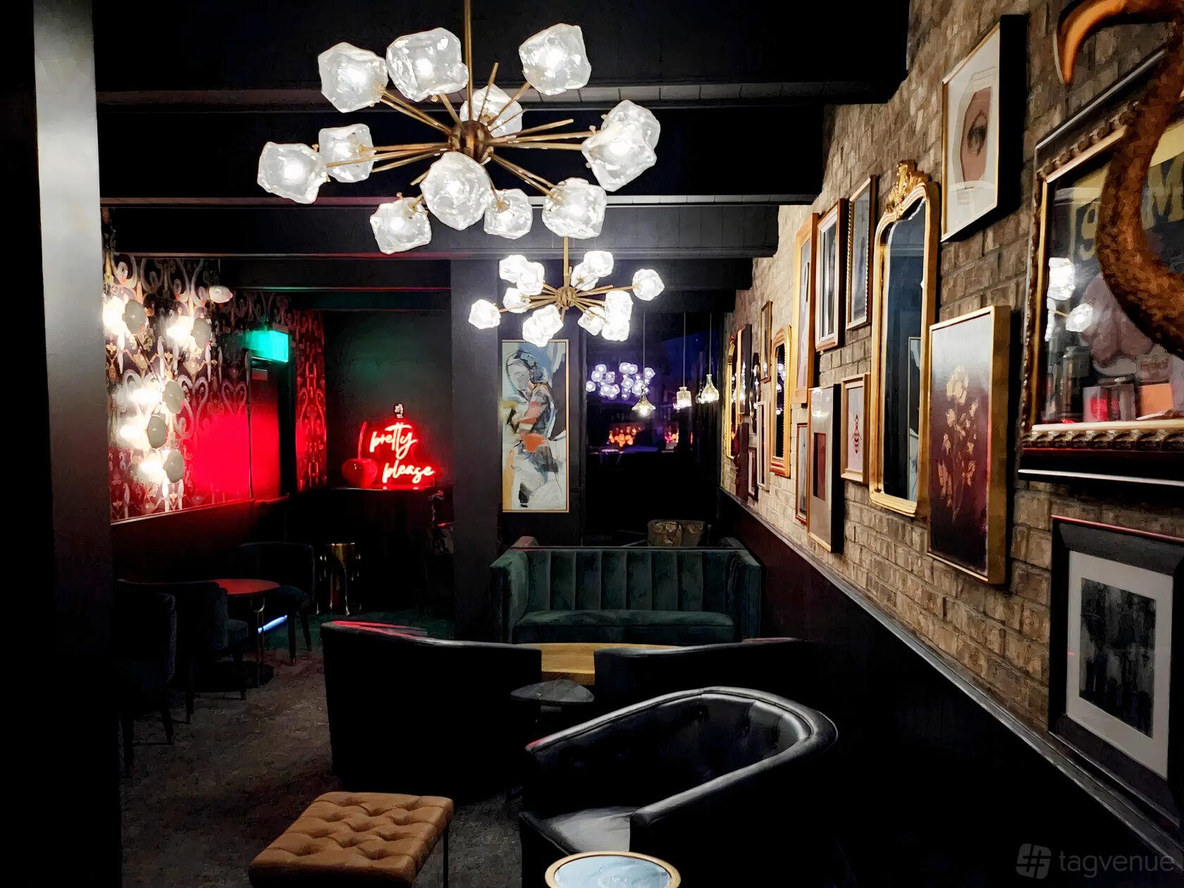 An event space in a bar with velvet seating, exposed brick walls, framed art, and geometric chandeliers at Renny's.