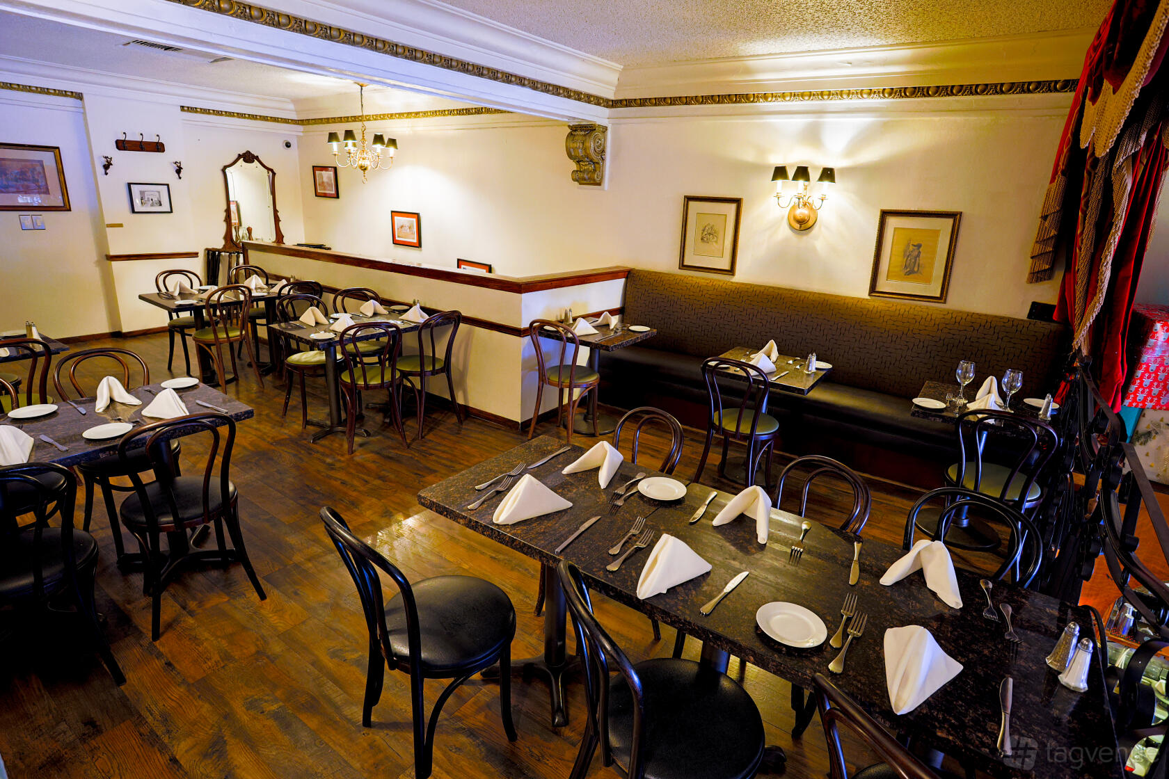 An event space in a restaurant with dark wooden chairs, marble tables, and white napkins at Dobson's Restaurant.