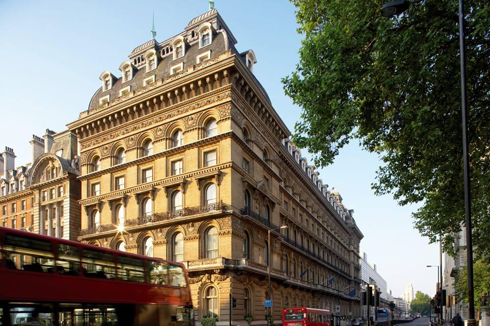 A historic hotel with ornate stone façade, arched windows, and mansard roof at The Clermont Victoria.