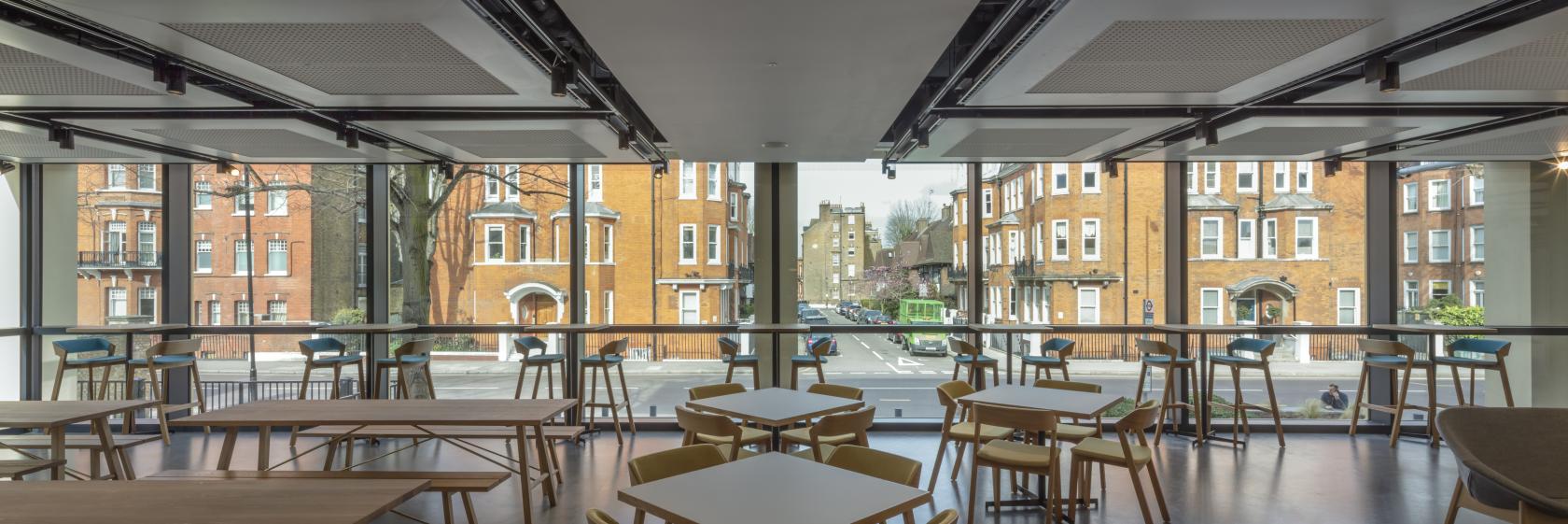 A museum cafe with floor-to-ceiling windows, wooden tables, and street views at National Army Museum.