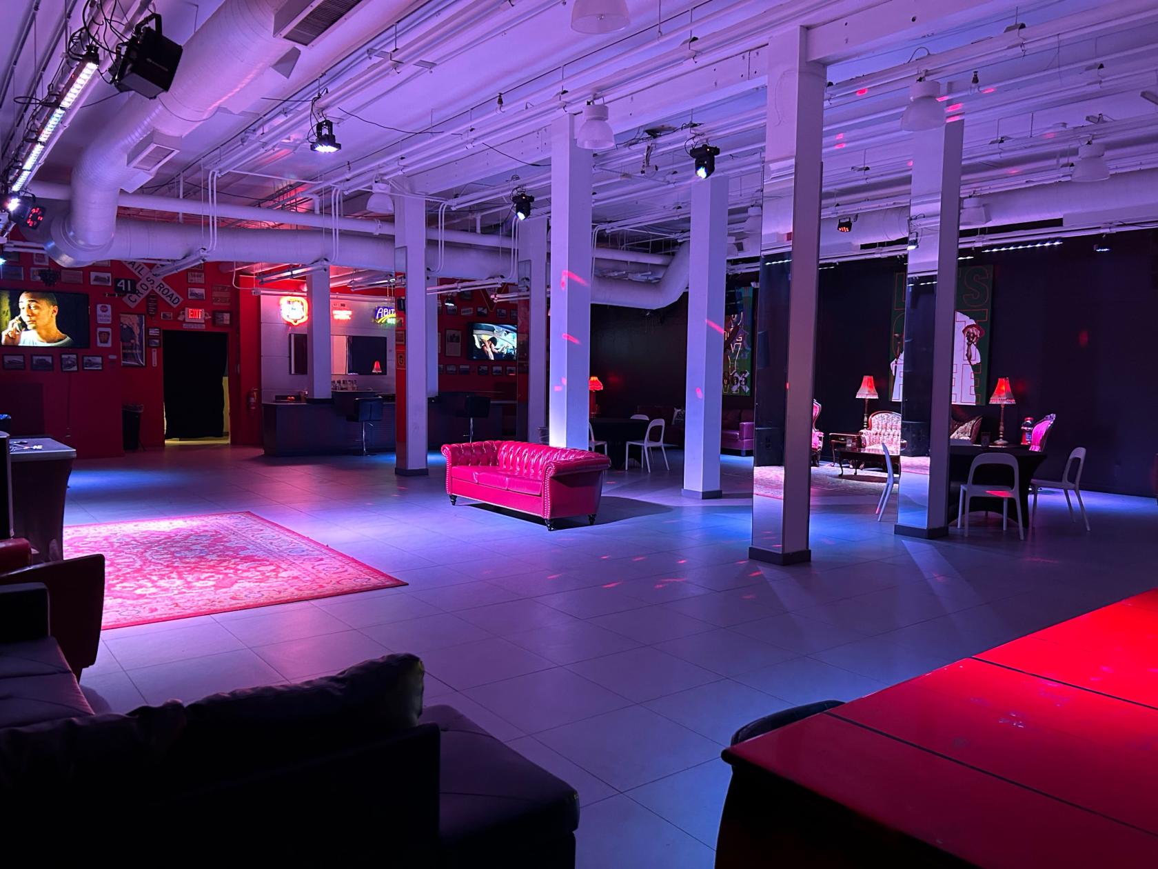 An event venue with a tiled floor, red leather couches, lounge seating, and ambient purple lighting at Event Space in Historic Downtown Atlanta.