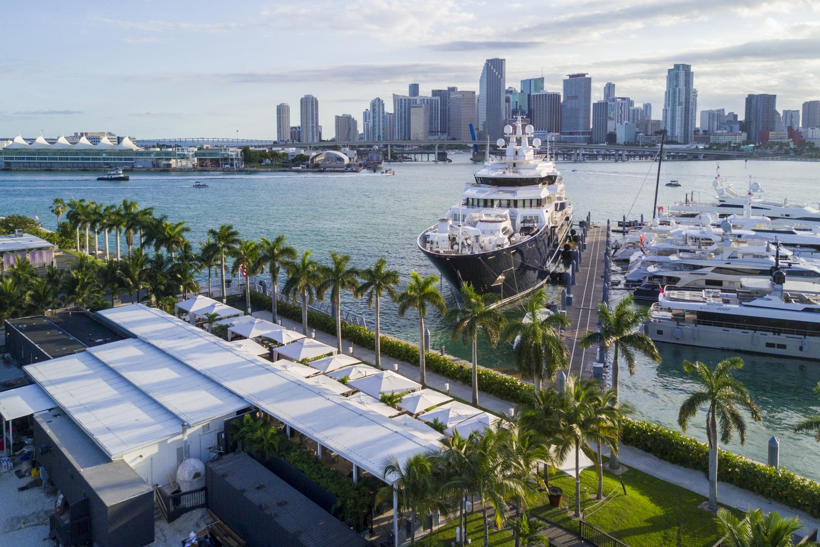 A versatile event space with waterfront views, yachts, and palm trees at Island Gardens.