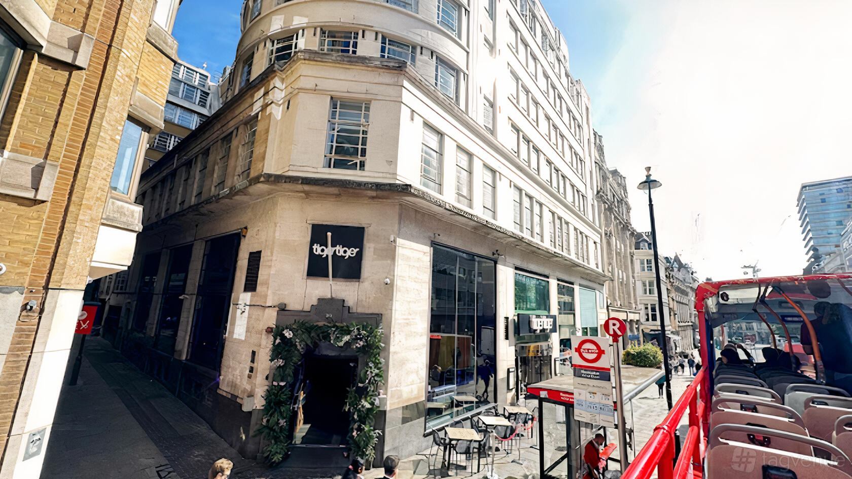 A nightclub with a stone exterior, large windows, and a leafy entrance at LUXE.