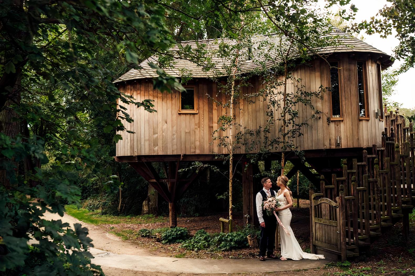 An event venue with a rustic wooden treehouse surrounded by lush greenery at The Woodlands.