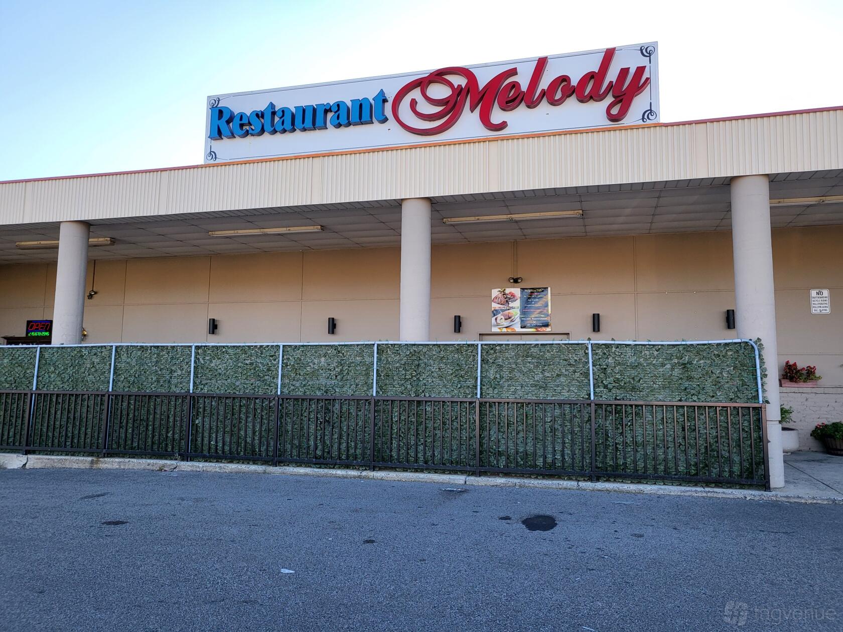 An event hall exterior with tall columns and a large 'Restaurant Melody' sign at Melody.