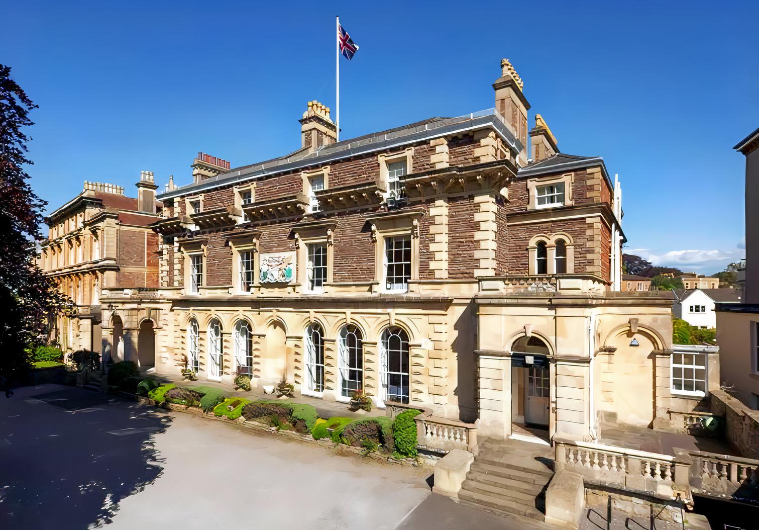 A historic building with arched windows, stone columns, and a flagpole above the entrance at Merchants' Hall.