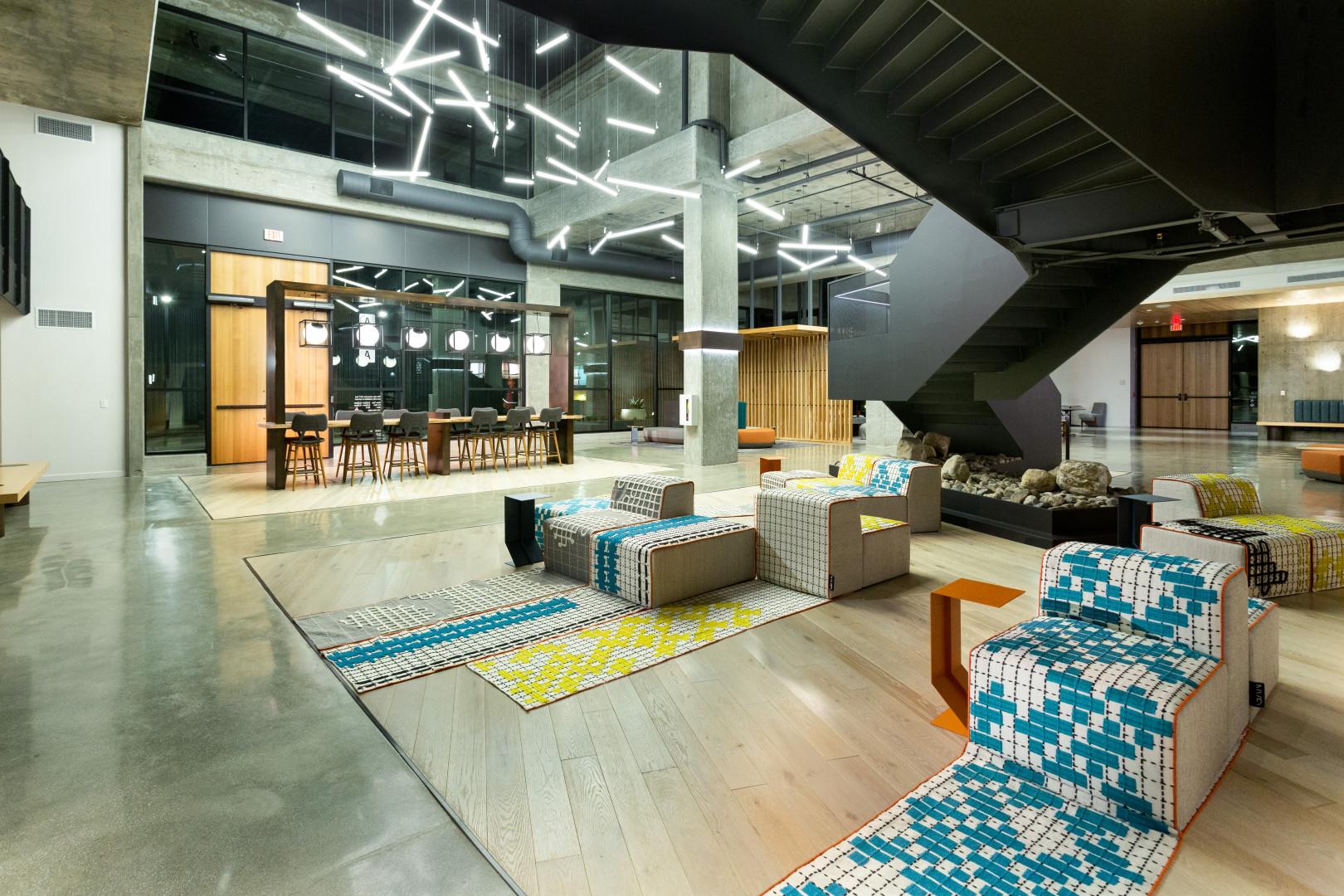 An event venue with geometric LED ceiling lights, polished concrete floors, and modular seating at The Ingrid Hollywood Event Space.
